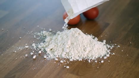 pastry preparation: super slow motion chef adding flour to wooden table with eggs