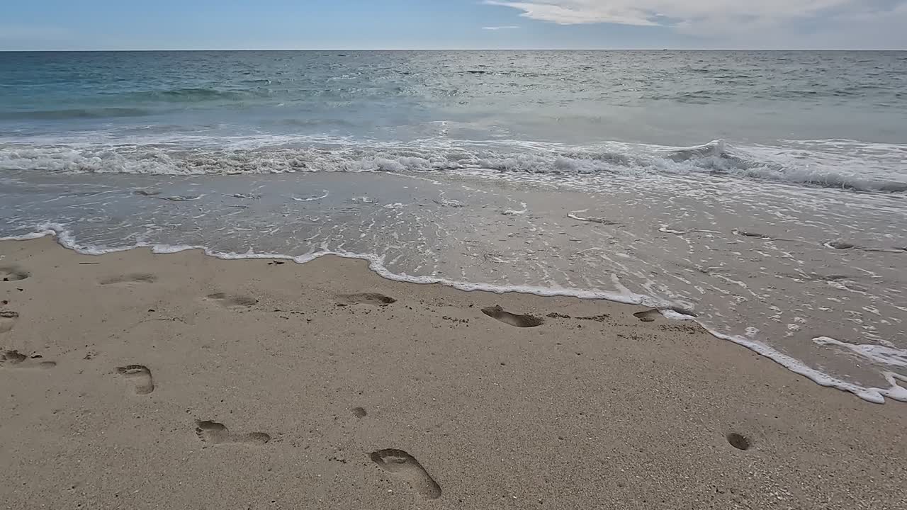 Orme spazzate via dalla prossima serie di onde in arrivo.