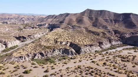 Desierto-De-Tabernas-En-Almería,-Andalucía,-España---Vista-Aérea-De-Drones-Del-Valle-Seco,-Lecho-Del-Río,-Montañas-Y-Parque-Temático-Leona-Occidental