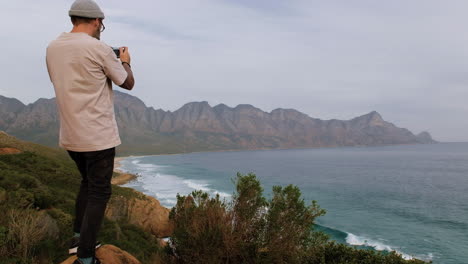 Hombre-Caucásico-Tomando-Fotos-Del-Océano-Desde-Un-Punto-De-Vista,-Sudáfrica