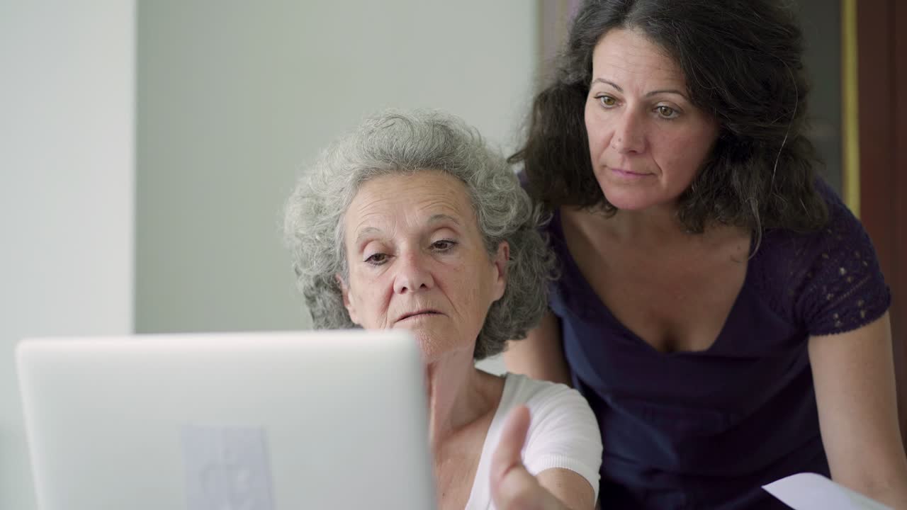 Fokuserade mogna anställda som arbetar med laptop