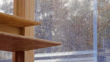 wooden table inside a transparent tent in a rainy day with water dripping