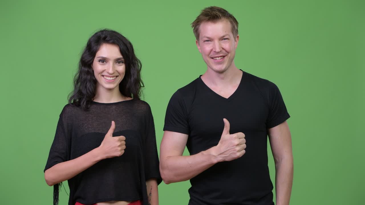 Young couple giving thumbs up together