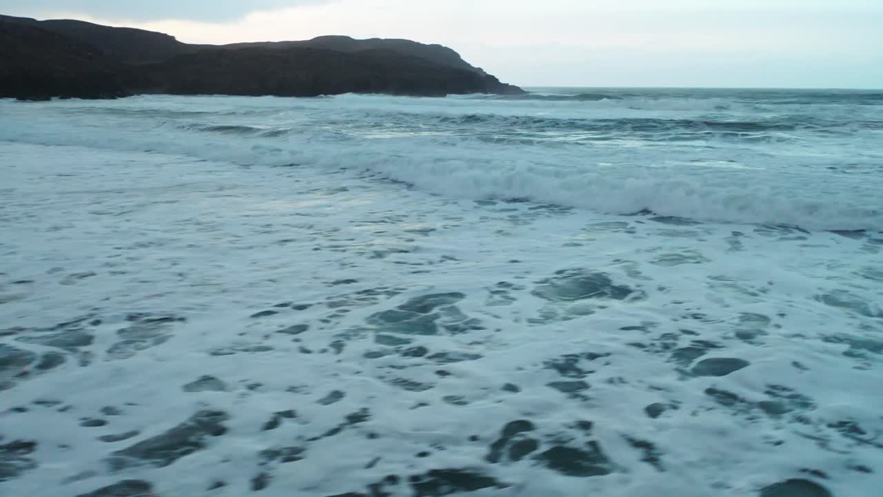 Ripresa con drone che segue un'onda che si infrange sulla spiaggia di Dalmore sull'Isola di Lewis