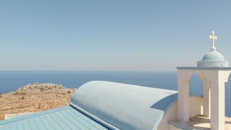 Iglesia-De-San-Rafail-Con-Mar-Azul-En-Calma-En-El-Fondo-En-Chania,-Grecia