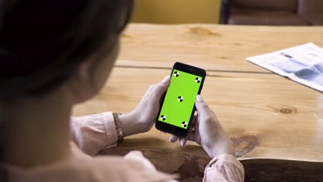 woman using a smartphone with green screen