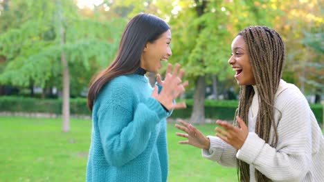 two happy friends embracing in a park