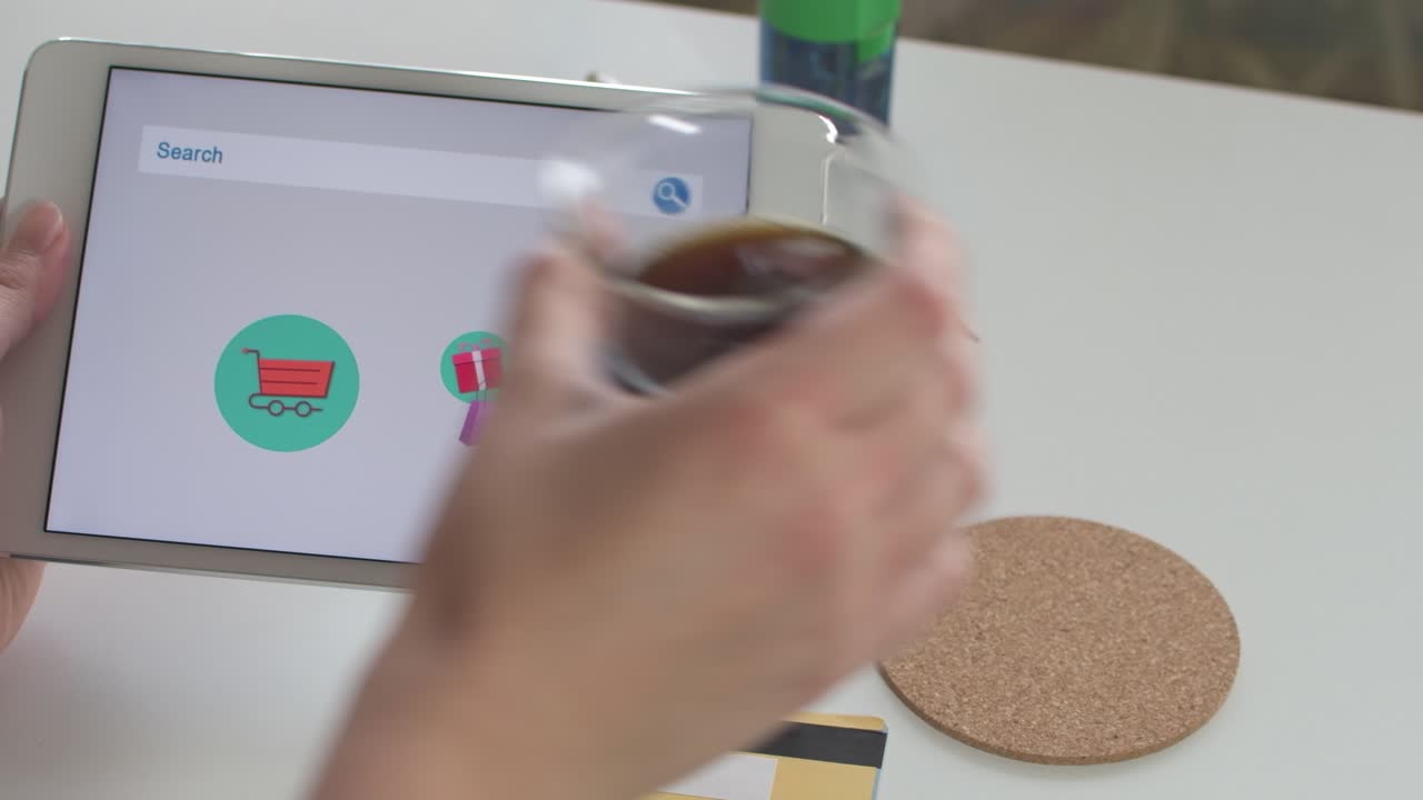 Woman's hands holding a tablet, buying gifts online, and paying with a credit card.