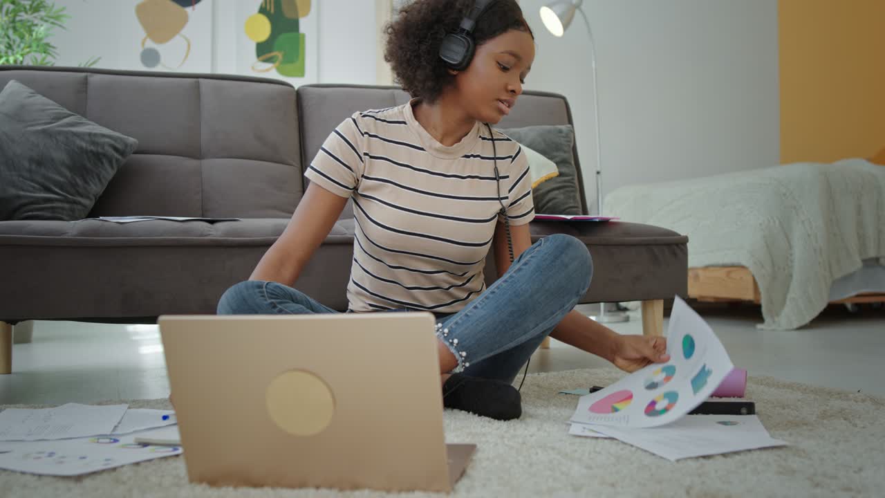 African American student listening to music and doing homework