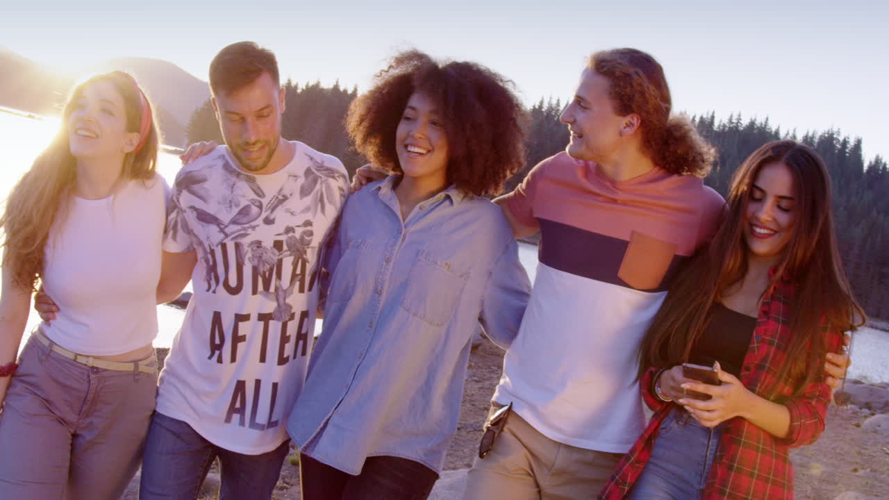 해가 지는 동안 호수변을 고 있는 친구들