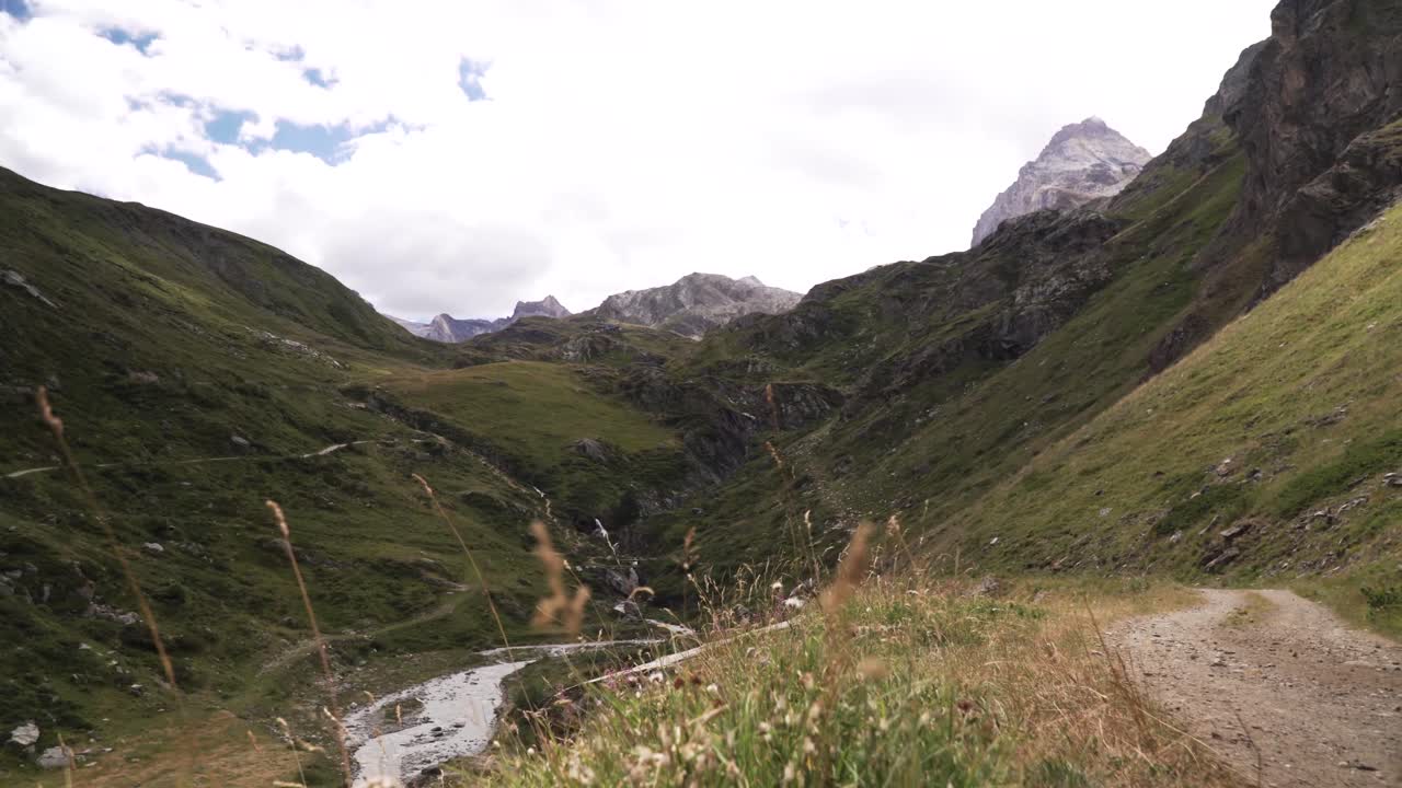 Low angle view of a glacier river running from a high rocky mountain peak