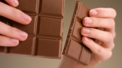 hands breaking a chocolate bar