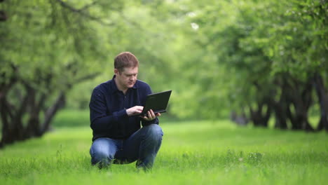 Mann-Arbeitet-Mit-Notebook-Im-Park