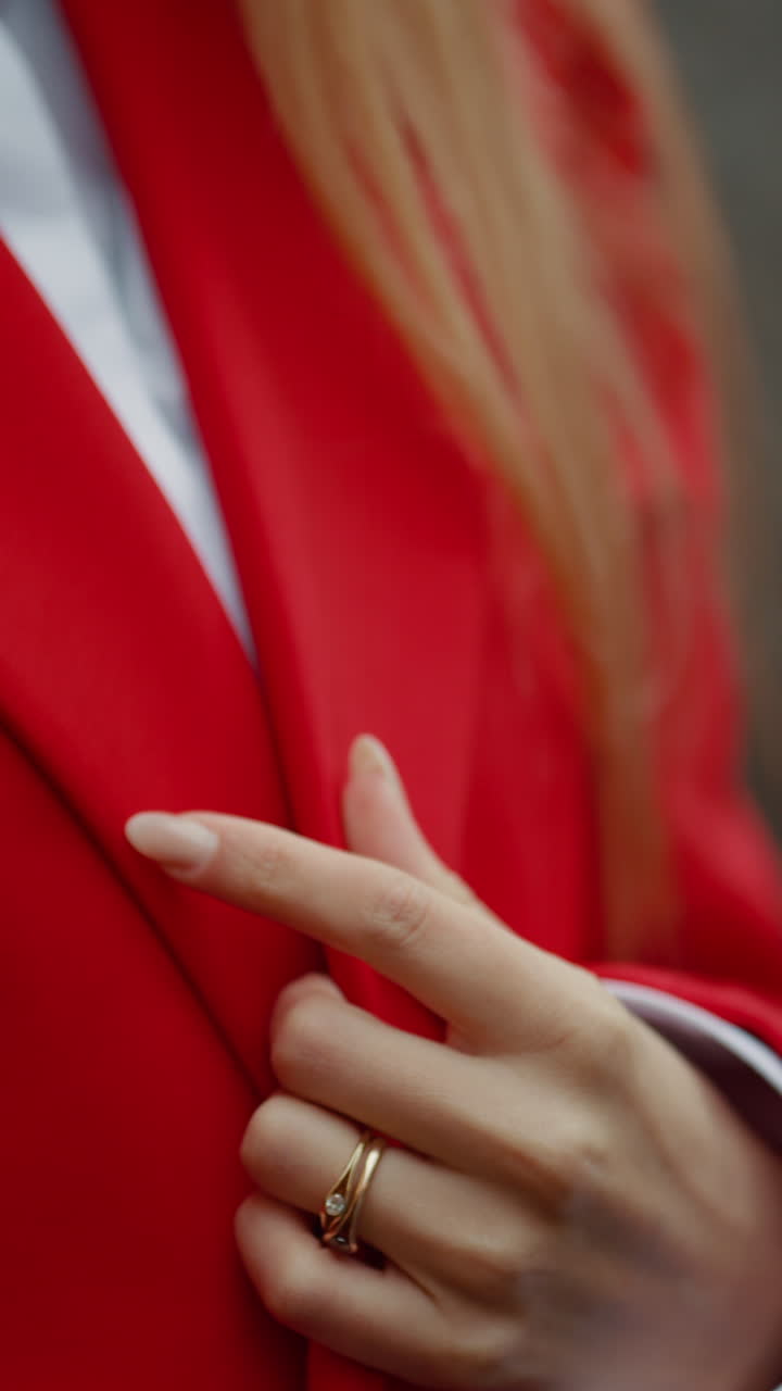 Woman in red blazer and gold ring