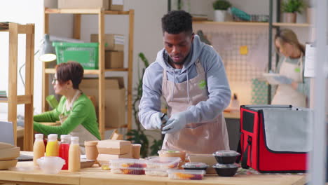 black man packing meals and drinks in food delivery bag
