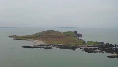 Una-Tranquila-órbita-Aérea-Captura-La-Isla-Del-Ojo-De-Irlanda-En-Una-Tarde-Serena