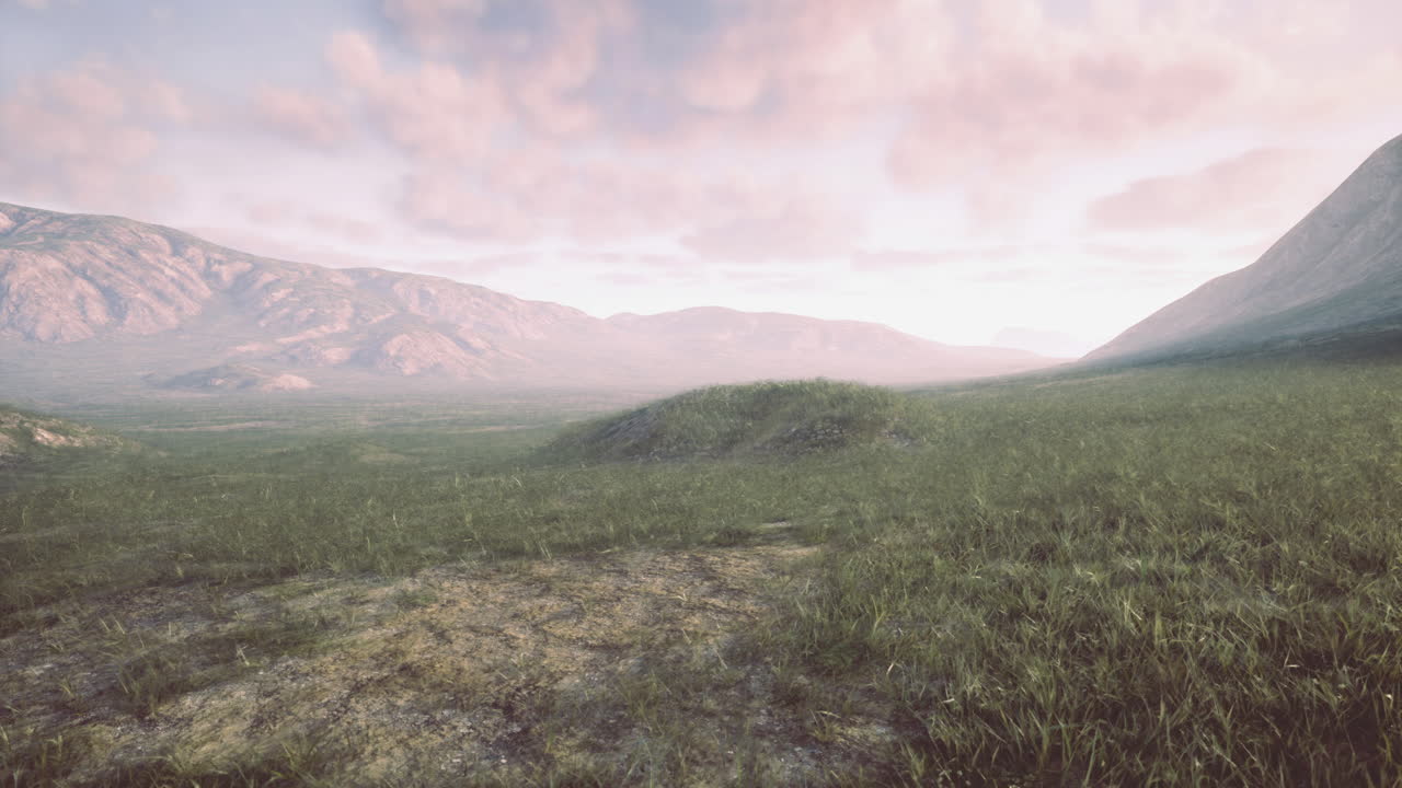 Landscape view of rolling hills and distant mountains during sunset