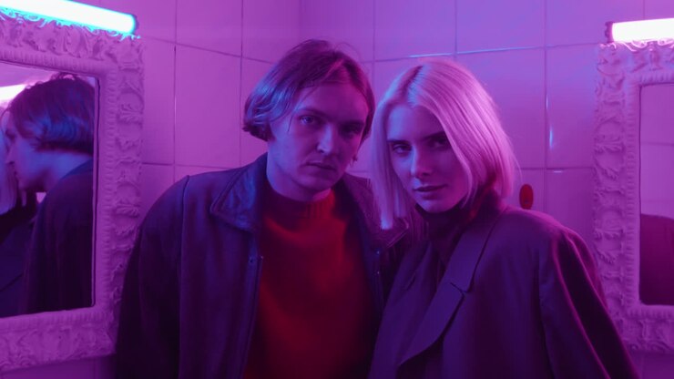 Portrait of Stylish Couple in Room with Neon Purple Light