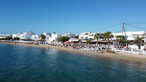 aerial view of naxos town houses and coastline on a beautiful day, greek island drone footage