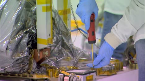 nasa engineers work on deep space equipment in a highly controlled clean room environment