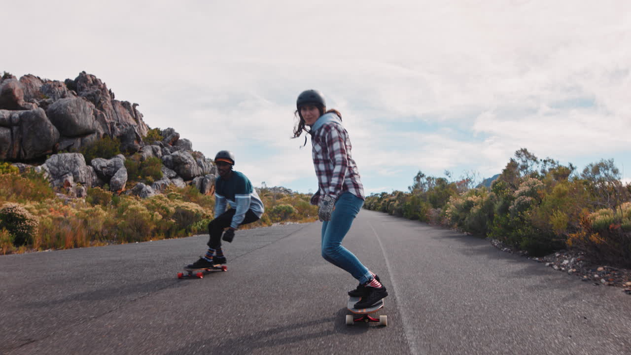 felices amigos multiétnicos longboarding juntos montando rápido en una hermosa carretera de campo disfrutando de unas vacaciones de verano relajadas crucero usando skateboard cámara lenta de cerca