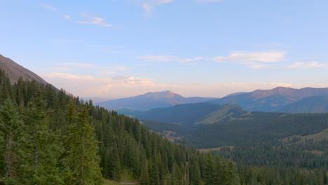 Antena-De-Montañas-Con-Tirón-Hacia-Atrás-Y-A-Través-De-árboles-En-Las-Montañas-Rocosas-De-Colorado