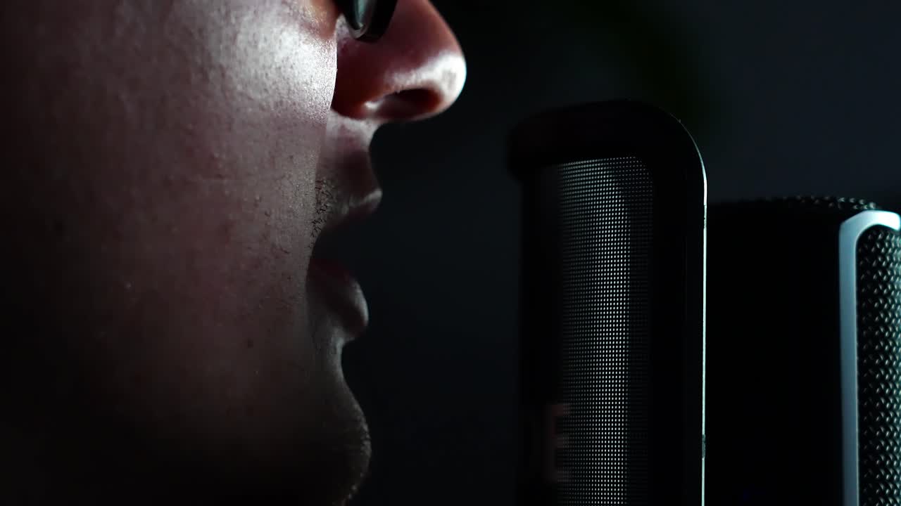 hombre cantando en el micrófono en el estudio de grabación