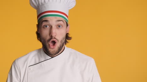 caucasian chef in front of camera on yellow background.