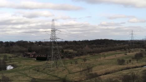 low aerial view flying electricity distribution power pylon overlooking british parkland countryside