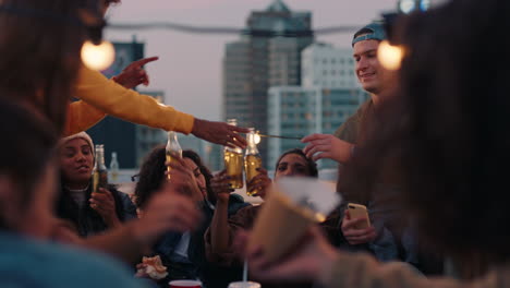 group of young friends enjoying rooftop party celebration drinking having fun chatting sharing friendship students making toast to summer vacation