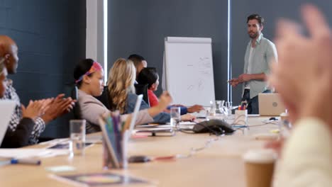 business executives applauding a colleague after presentation