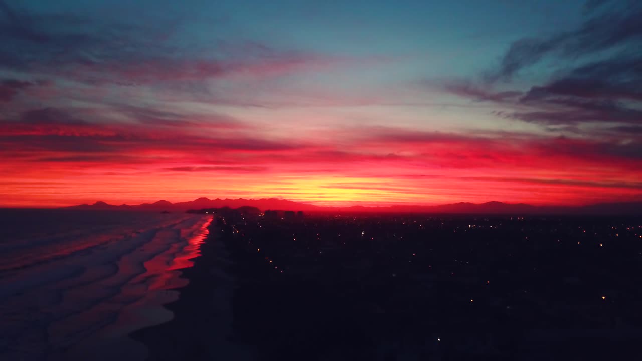 impresionante aerila 4k toma de la playa de itanhaem a última hora de la noche con un cielo de color loco y el océano en el fondo, brasil