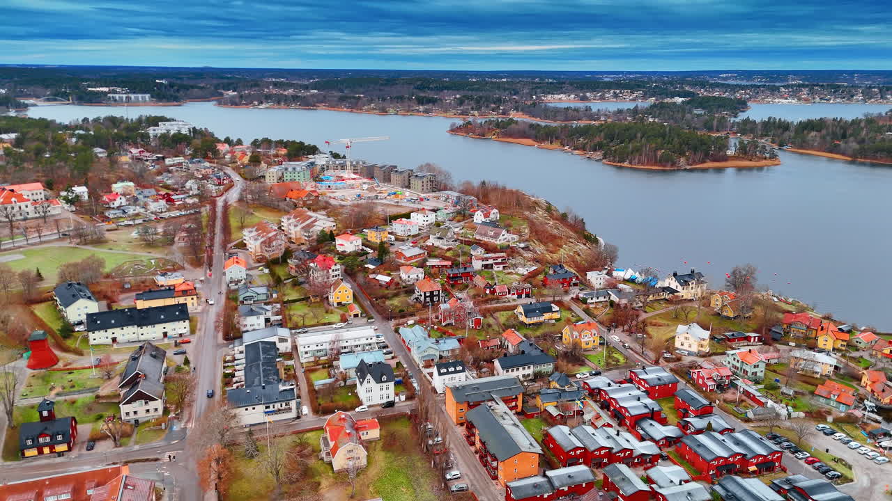 Ilmakuva asuinalueesta ja rakennustyömaasta Vaxholmissa. Korkealta otettu näkymä punaisista puutaloista ja uudesta rakennusprojektista Ruotsin rannikon lähellä.