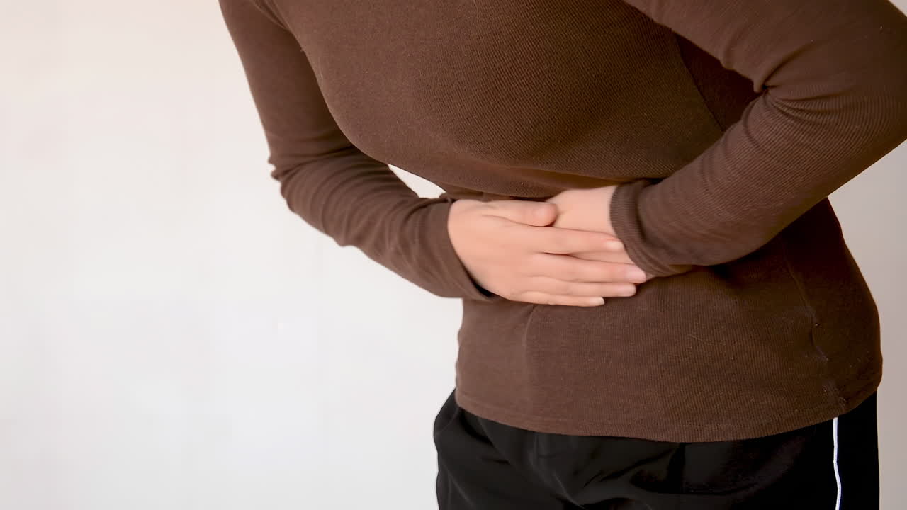 Young teenage girl having stomach pain ache at home