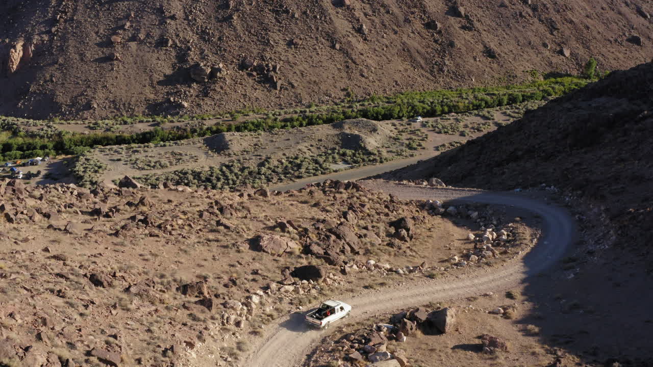 황량한 풍경을 통해 도로를 따라 차를 쫓는 사막 위의 비행