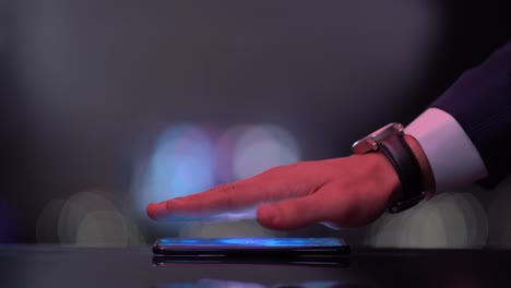 la mano sobre el teléfono revela la palabra holograma economía del comportamiento