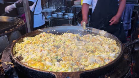 chef cooking fried mussels omelet on hot pan-hoy tod