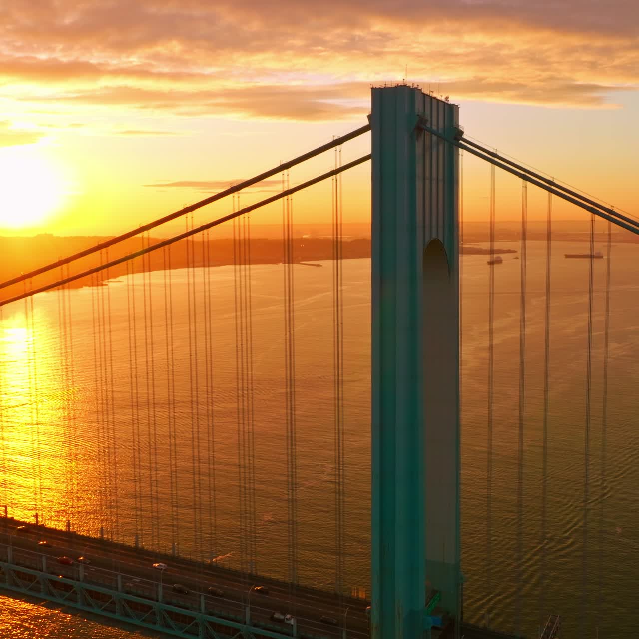 Blue massive supports of Whitestone bridge in the orange light. Beautiful picture of sunset over East River