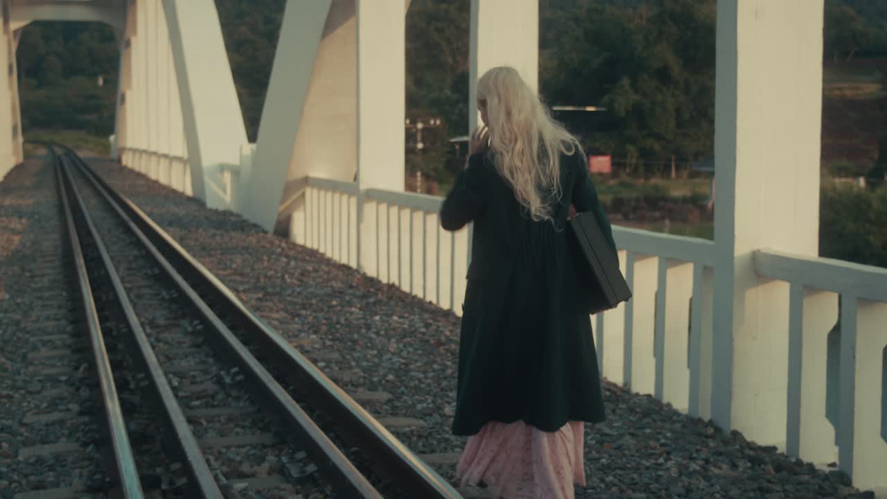 Woman walking on a railway bridge