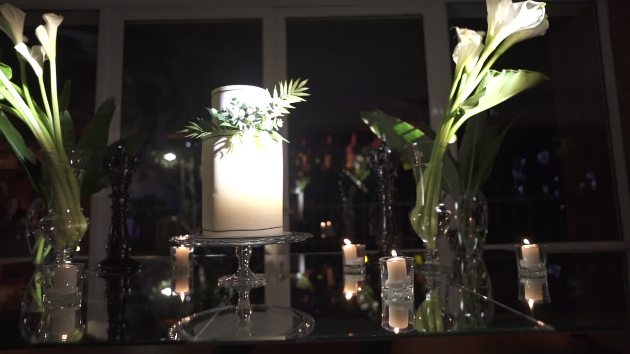 Ornate wedding cake in floral setting with soft candlelight and warm, romantic details