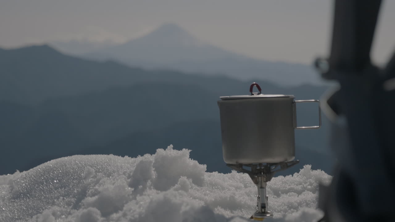 겨울 산에서 물을 끓이는 남자