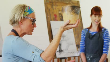 maestra de dibujo ayudando a una mujer en cerámica 4k