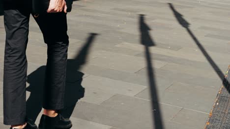 a person walking on a sidewalk casting shadows