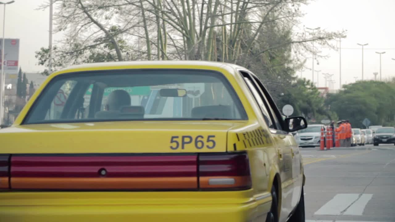 Taxi giallo che si allontana su una strada urbana