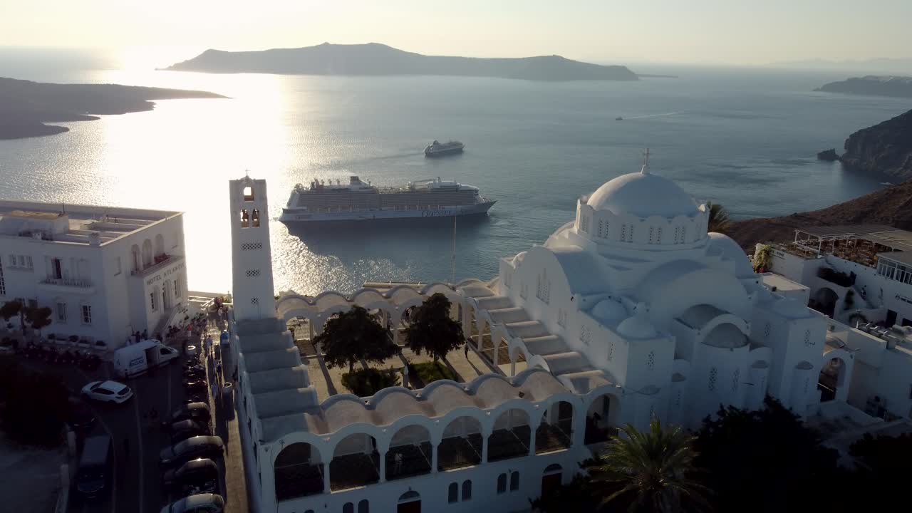 aérea sobre la catedral ortodoxa de fira revelando el viejo puerto cruceros de la bahía, santorini, grecia