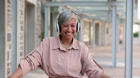 senior woman, headphones and dancing in city