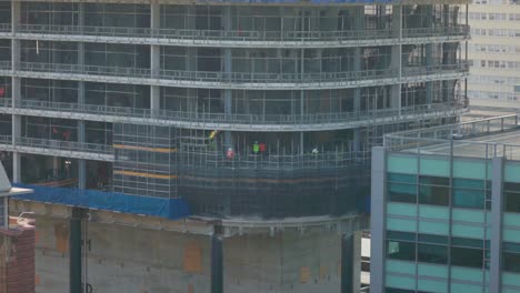 workers construct scaffolding on a high-rise building site in sydney, highlighting the skilled labor behind urban development in australia’s largest city.