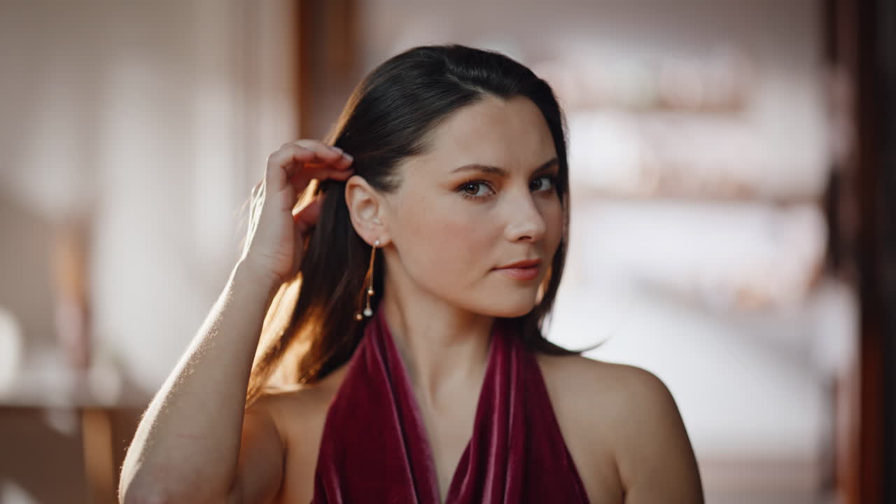 Elegant model adjusting hair looking mirror closeup. Smiling gorgeous woman