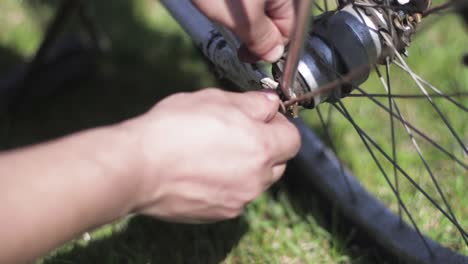 screwing a screw on a wheel of a bike. repairing an old bicycle close up.