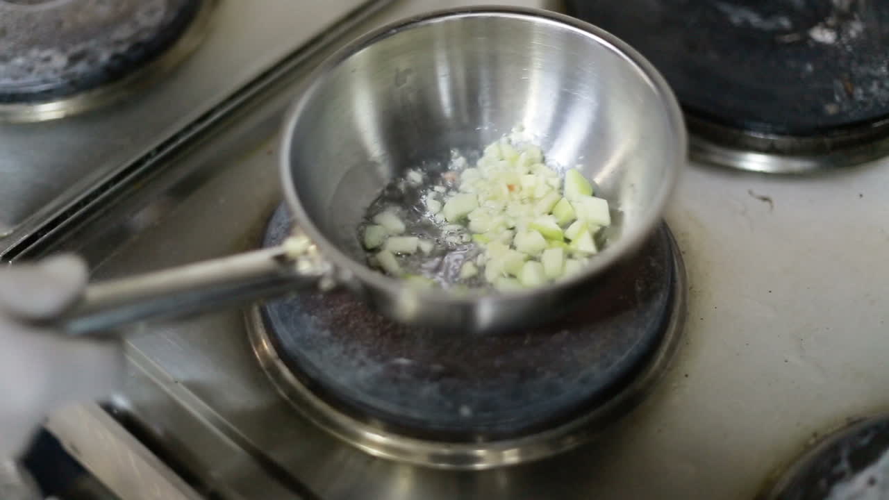 Onion Frying In A Pan. Fried onions in a frying pan in oil, for cooking